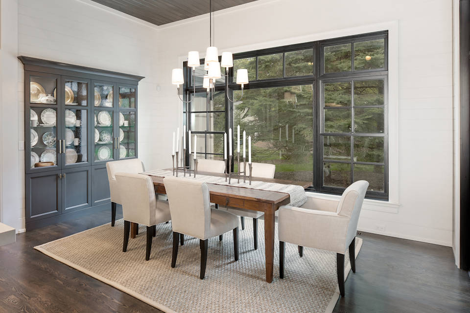 A dining room with wood floors and a large window.